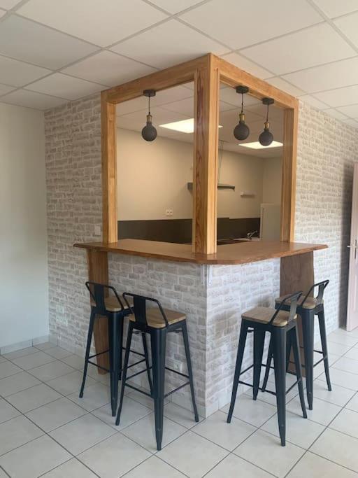 - un bar avec quatre chaises et un comptoir avec un miroir dans l'établissement Confortable au pied du Vercors, à Pont-en-Royans