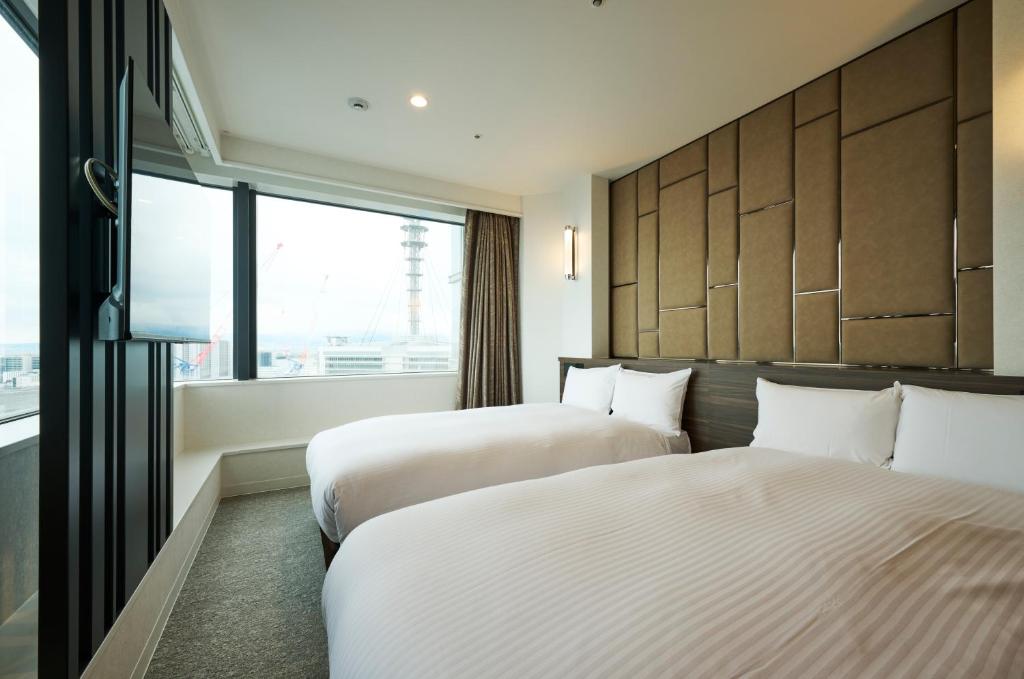 Postel nebo postele na pokoji v ubytování HOTEL FUKURACIA OSAKA-BAY