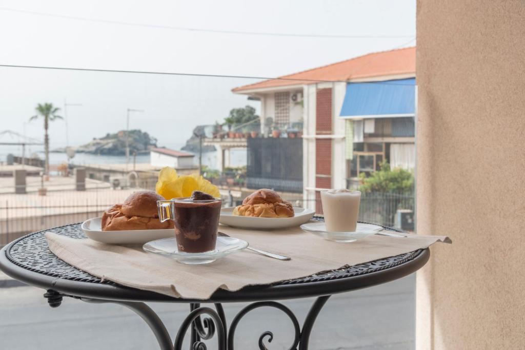 a table with two plates of food and two cups of coffee at La Finestra di Verga in Aci Castello
