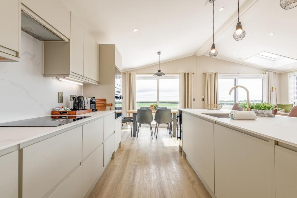 a kitchen with white cabinets and a table with chairs at Eden View Estate - Eden Lodge in St. Andrews