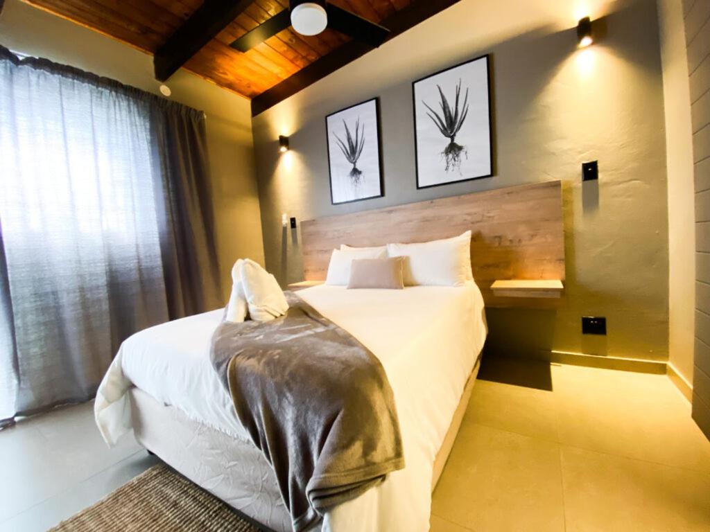 a bedroom with a bed and two pictures on the wall at The Mole Guesthouse in Swakopmund