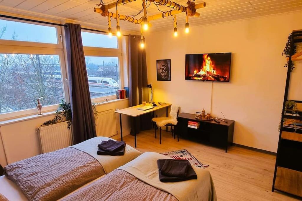 a bedroom with two beds and a desk with a fire on the wall at Celle Apartment for 6 people in Celle