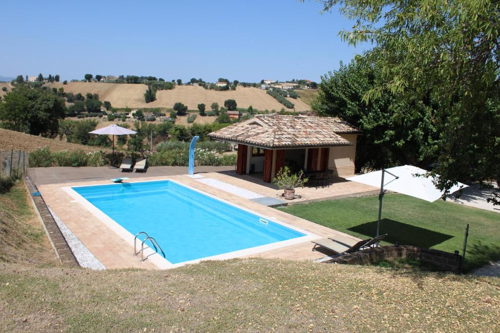 a swimming pool in front of a house at B&B Profumo delle Marche in Montefano