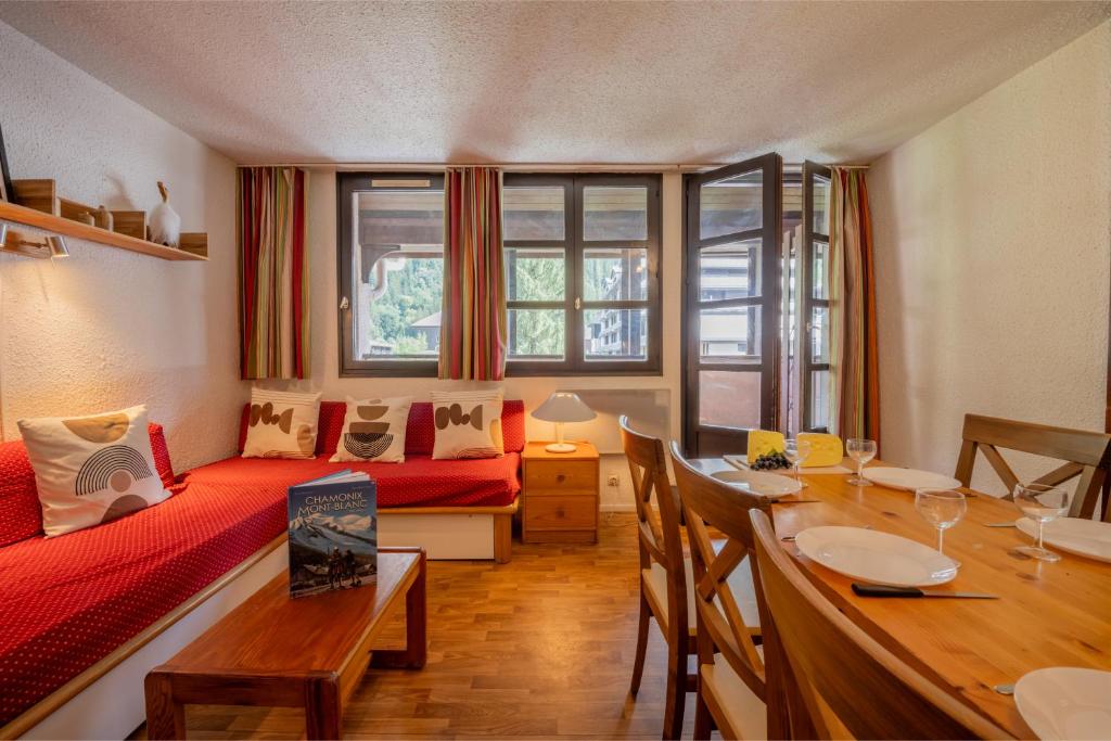 - un salon avec un lit rouge et une table dans l'établissement Chamonix Sud - Jonquilles 328 - Happy Rentals, à Chamonix-Mont-Blanc