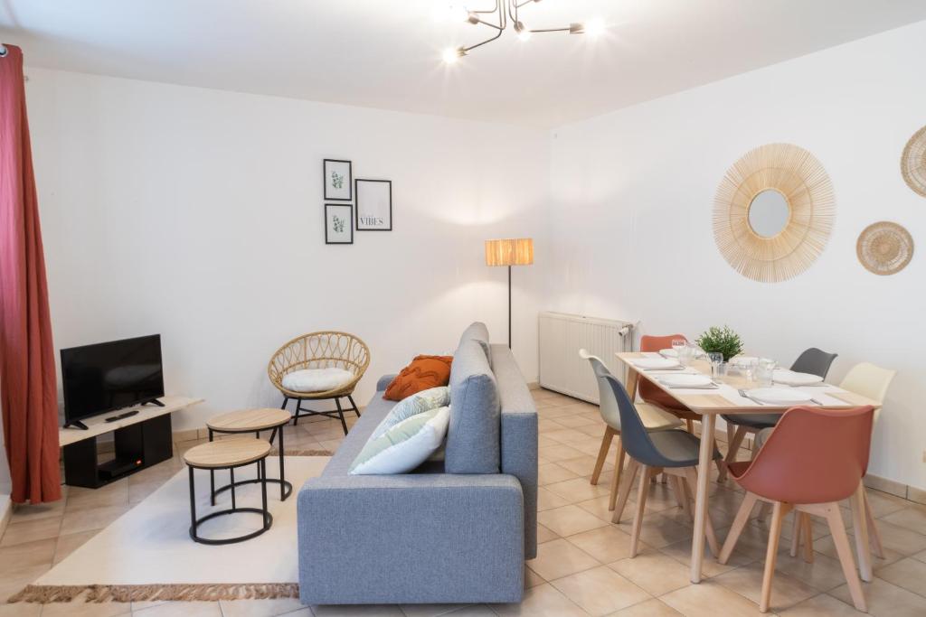 un salon avec un canapé bleu et une table dans l'établissement Charmant duplex T3 centre historique Muret, à Muret