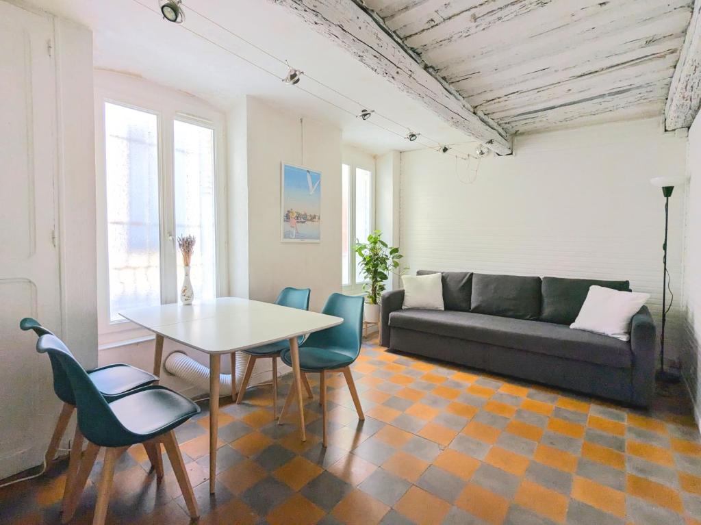 un salon avec une table, des chaises et un canapé dans l'établissement Cozy Apartment Intramuros near the Station, à Avignon