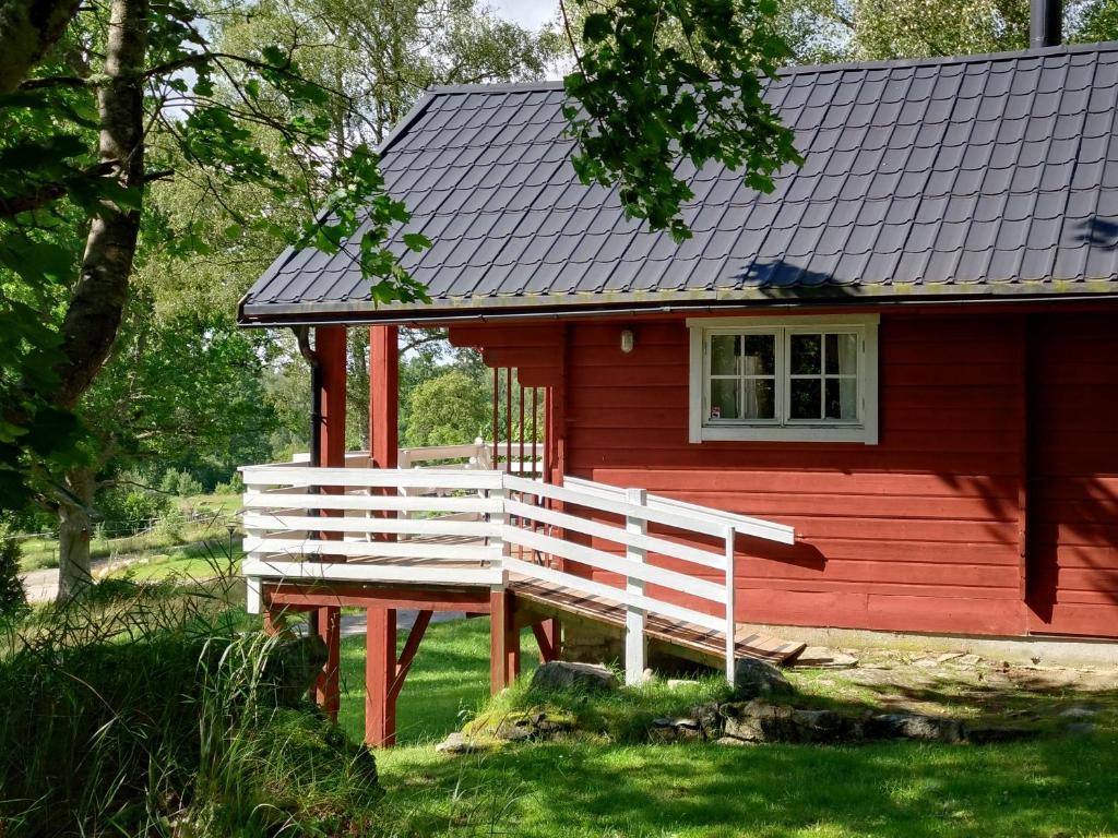 a red house with a bench in front of it at Rolsmo Norregård 16 in Linneryd