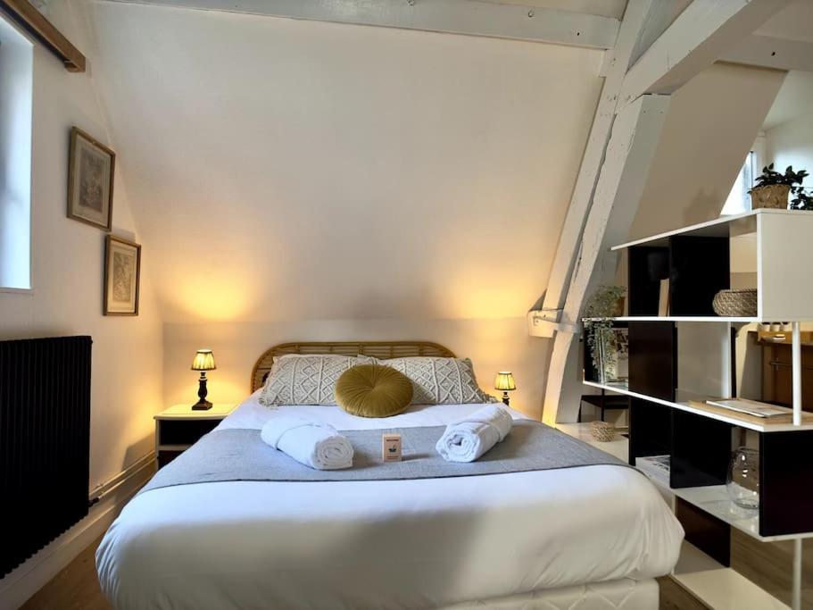 a bedroom with a large bed with towels on it at Rouen Hyper centre - L'Antiquaire in Rouen