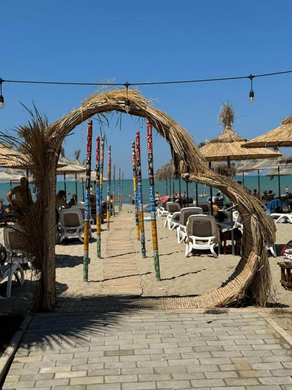 a rope archway on a beach with chairs and umbrellas at Comfort Suites in Golem