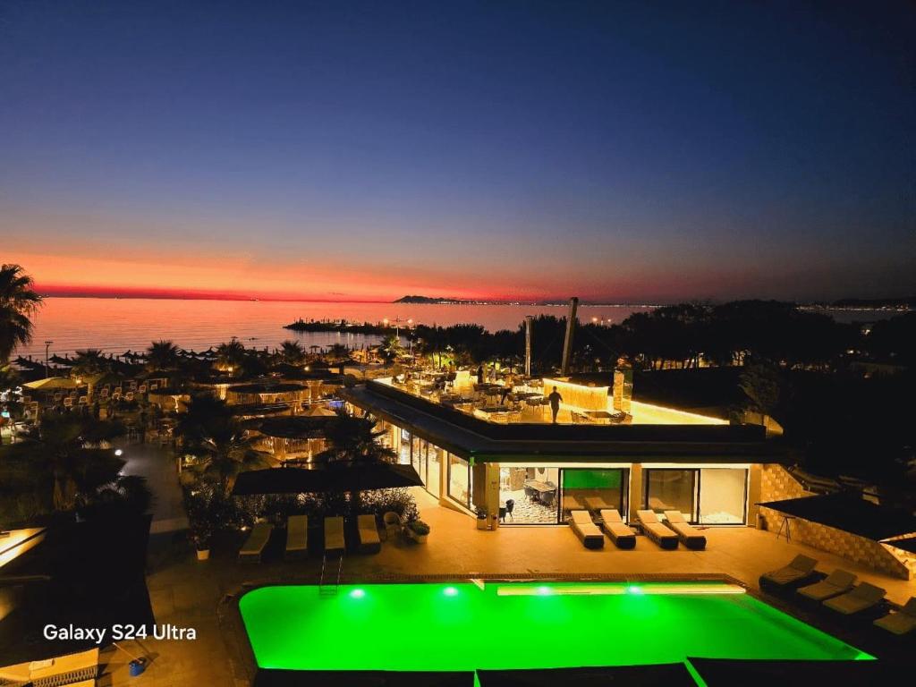 a house with a green pool in front of the ocean at Comfort Suites in Golem