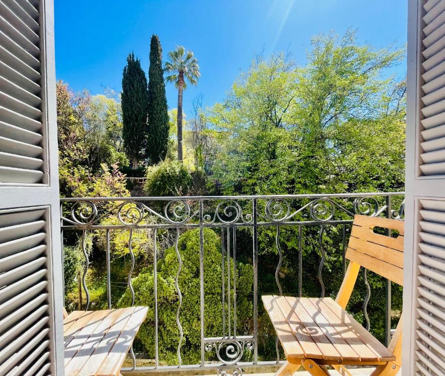d'un balcon avec deux chaises et un palmier. dans l'établissement Cimiez studio aperçue Mer, à Nice