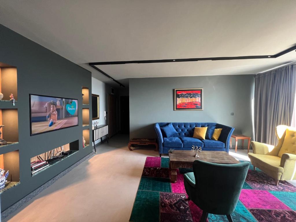 a living room with a blue couch and a table at Apartament Panorama in Pomorie