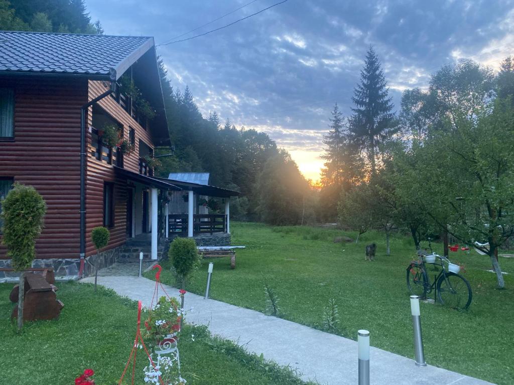 una casa con la puesta de sol en un patio en Cabana Briana, en Borşa