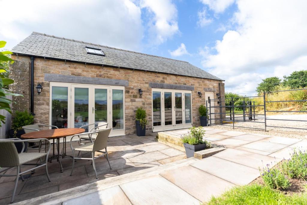 a patio with a table and chairs in front of a building at Short Croft Cottage - Idyllic, dog-friendly country retreat in Holbeck