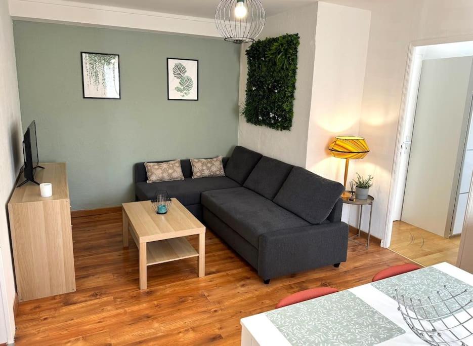 a living room with a couch and a table at Appartement Zola in Jarny