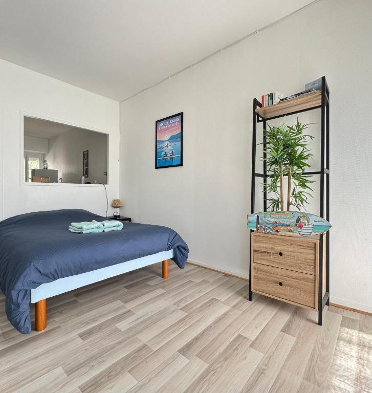 une chambre avec un lit et un parquet dans l'établissement Charmant T1 entre ville et lac avec balcon, à Aix-les-Bains