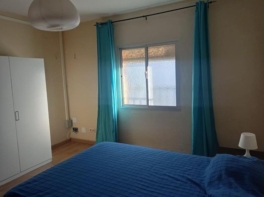 a bedroom with a blue bed and a window at Casa de la Ermita in Alhaurín de la Torre
