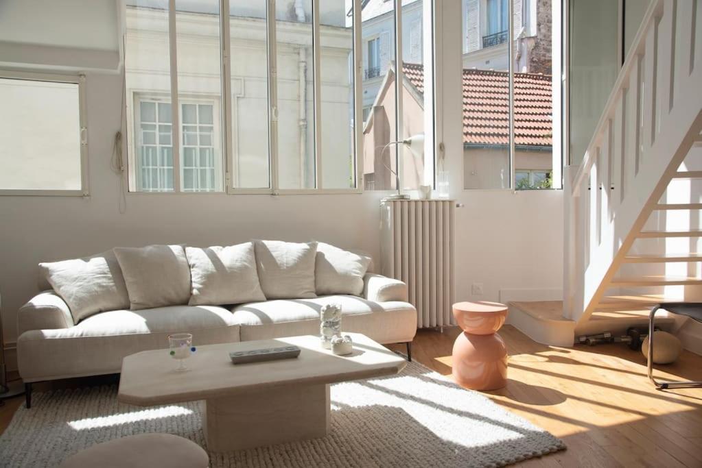 un salon avec un canapé et une table basse dans l'établissement Triplex lumineux avec balcon - 500m Champs Elysées, à Paris