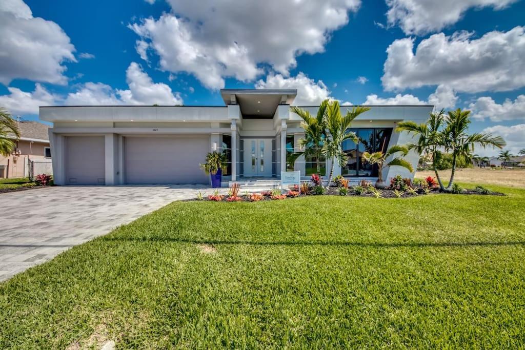 une maison avec une pelouse verte devant dans l'établissement Villa Perfection by CoralVilla- luxurious, sun deck on water, à Shell Point Village