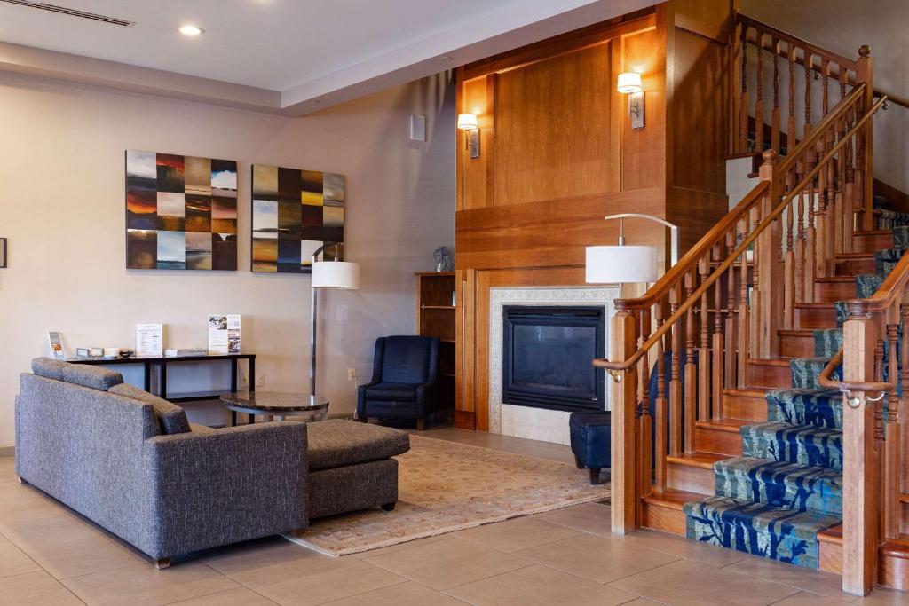 a living room with a staircase and a fireplace at Country Inn & Suites by Radisson, BWI Airport Baltimore , MD in Linthicum Heights