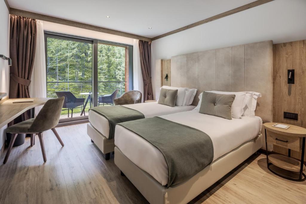 a hotel room with two beds and a desk at Cervino - VRetreats in Breuil-Cervinia