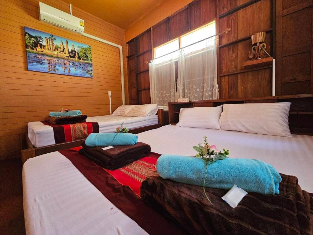 Postel nebo postele na pokoji v ubytování บ้านเรือนไทยมะลิเมืองเก่า