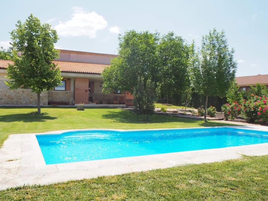 a swimming pool in the yard of a house at La casa de Blas in Valoria la Buena