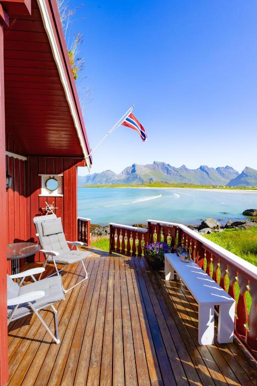 a house with a deck with a view of the water at HeiaHytta Fredvang in Fredvang