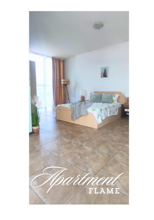 a bedroom with a bed and a tiled floor at Апартамент FLAME in Sunny Beach