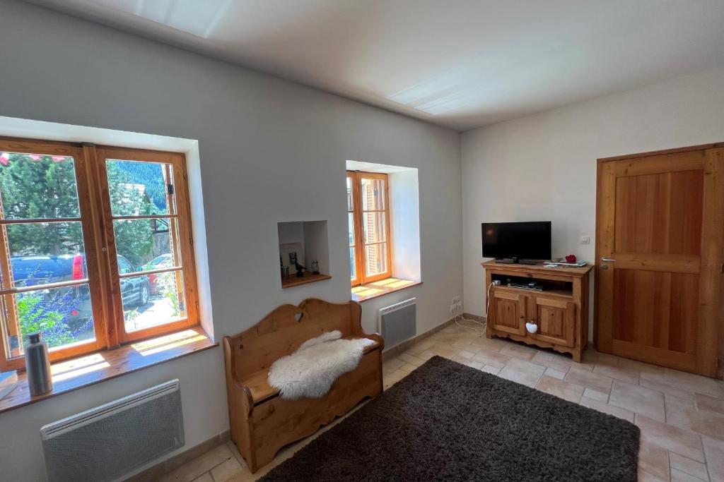 - un salon avec un canapé, une télévision et des fenêtres dans l'établissement T2 apartment with parking, à La Salle Les Alpes
