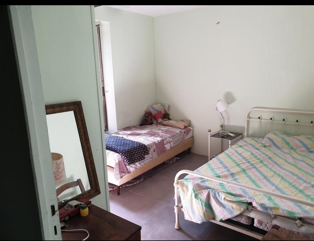 une petite chambre avec un lit et un miroir dans l'établissement Maison de famille, à Montséret