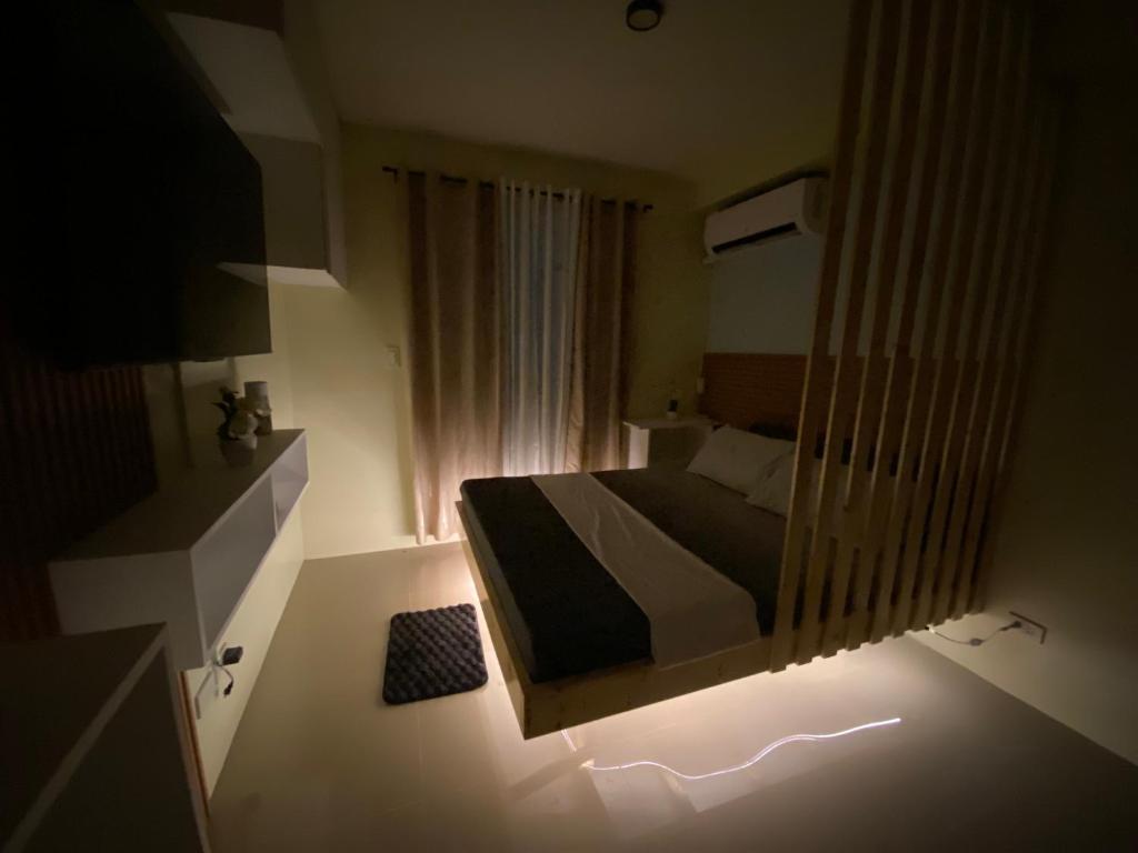 Schlafzimmer mit einem Bett und einem Spiegel in der Unterkunft Cathalia staycation in Lapu Lapu City