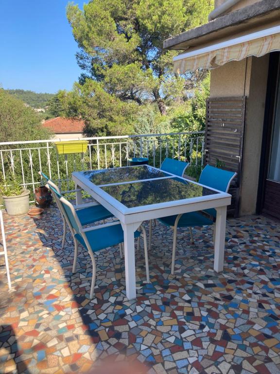 une table blanche et des chaises sur une terrasse dans l'établissement Maison lumineuse, à Bagnols-sur-Cèze