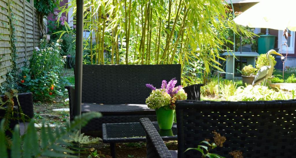 a patio with two chairs and flowers in a garden at Hôtel Vauban in Belfort