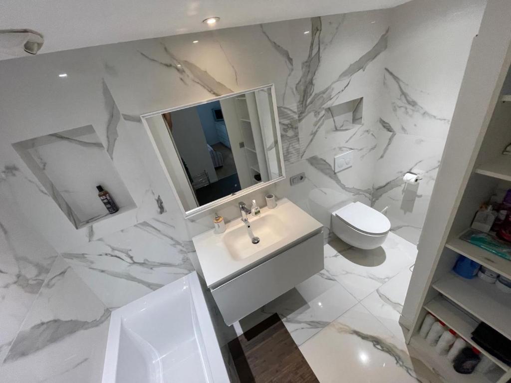 a white bathroom with a sink and a toilet at Monaco Monte-Carlo door step - Luxury Apartment - 2 Bedrooms 2 Bathrooms - Superb Modern Fully Equipped in Saint-Antoine