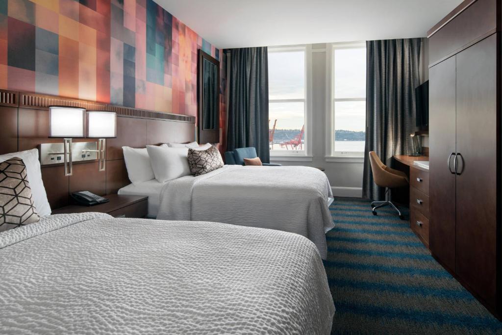 a hotel room with two beds and a desk at Courtyard Seattle Downtown / Pioneer Square in Seattle