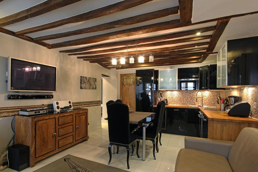 un salon avec une table et une cuisine dans l'établissement Appartement spacieux au cœur de Paris 75 m² avec vue sur la ville, à Paris