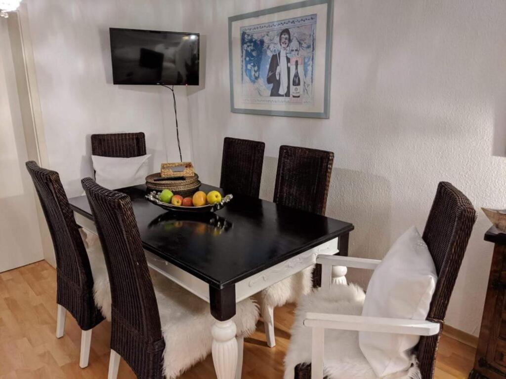 a black dining room table with chairs and a bowl of fruit at Apartment zu Hofe in Oberursel