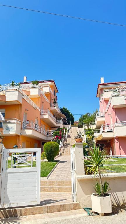 a row of houses with a white gate and stairs at Gorgona Di Thassos in Limenaria