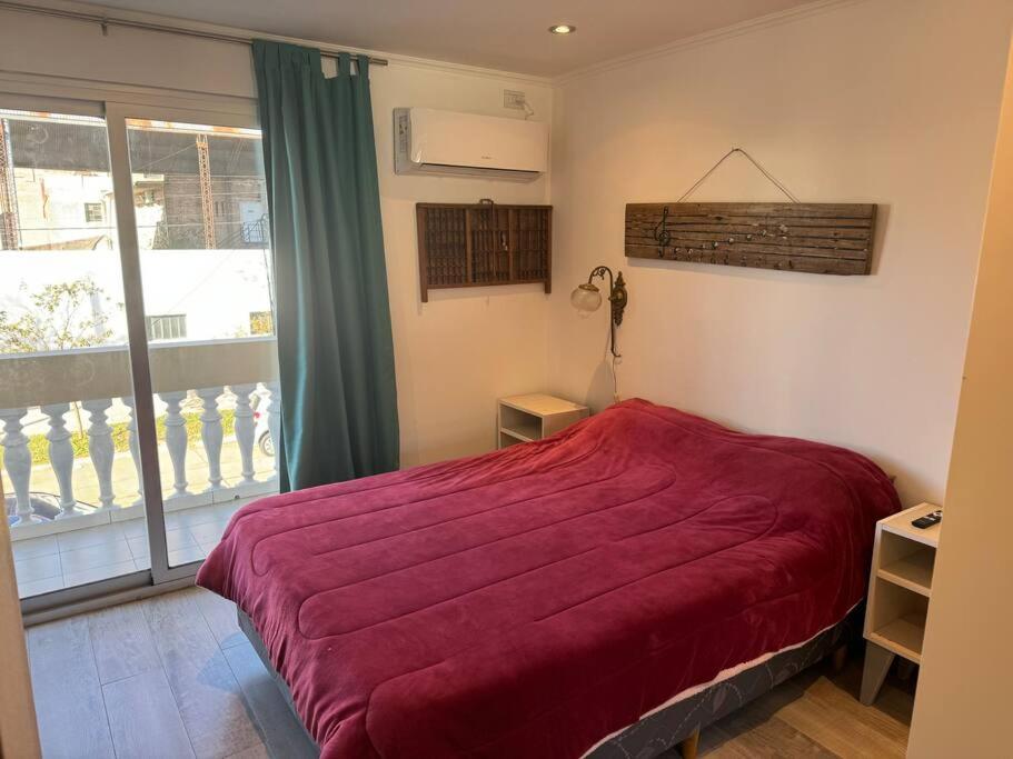 ein Schlafzimmer mit einem roten Bett und einem Fenster in der Unterkunft ApartaHotel Lacatedral in Reconquista