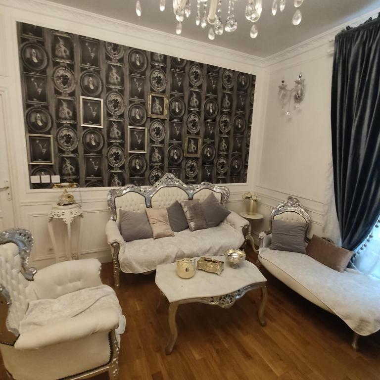 - un salon avec deux canapés et un mur avec des assiettes dans l'établissement Cosy Flat 8e Champs-Elysées, à Paris