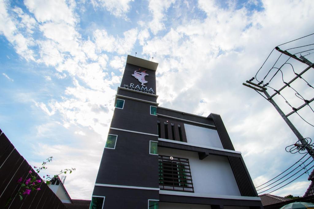 un grand bâtiment avec un panneau en haut dans l'établissement The Rama Hotel, à Chiang Rai