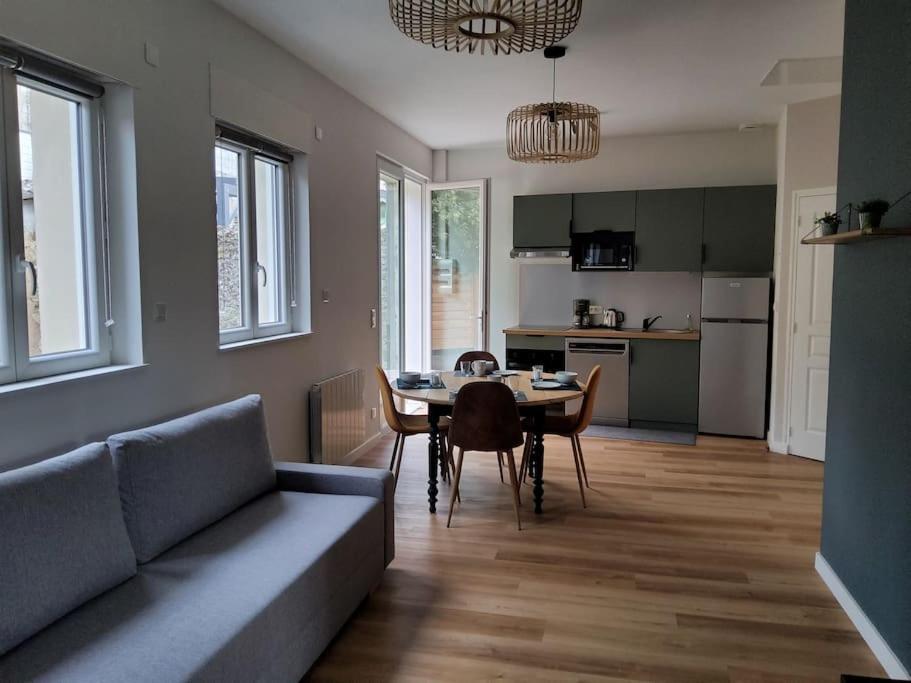 un salon avec un canapé et une table avec des chaises dans l'établissement La blanche école, à Rochefort-sur-Loire