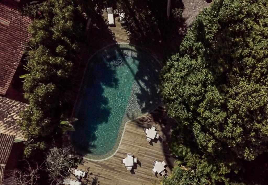 an overhead view of a swimming pool in a yard with trees at Pousada Capim Santo in Trancoso