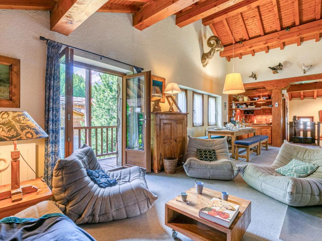 Una sala de estar con sofás y una mesa. en Chalet individuel, chaleureux avec cheminée et WIFI à Val-d'Isère - FR-1-694-99, en Val dʼIsère