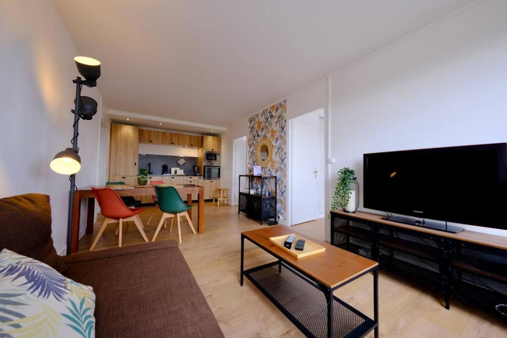 un salon avec une grande télévision à écran plat dans l'établissement Rouen Hypercentre - Seine en vue, à Rouen