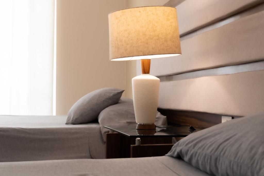 a lamp on a night stand next to a bed at Infinity Suites doble room 102 in Cancún