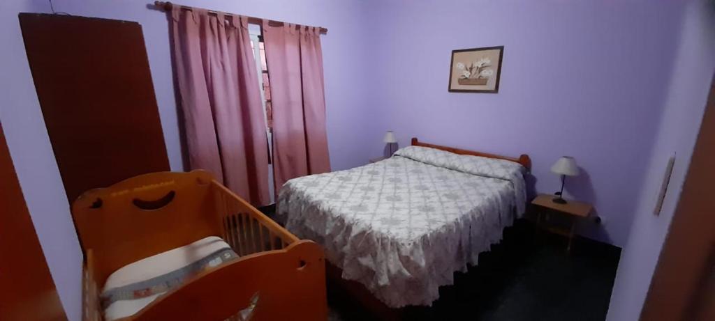een slaapkamer met een bed en een kinderbedje erin bij Cabaña La Cumbre Palermo in La Cumbre