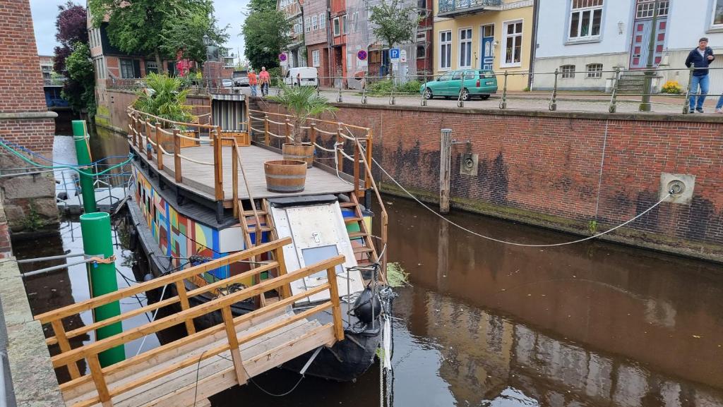 a boat docked in a canal in a city at Schute "Kunstkudder" im Hansehafen in Stade