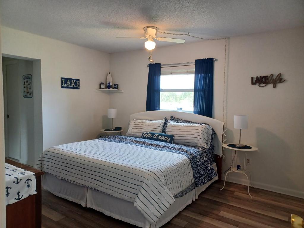 a bedroom with a bed with blue curtains and a window at Lakes For Daze in Lake Placid